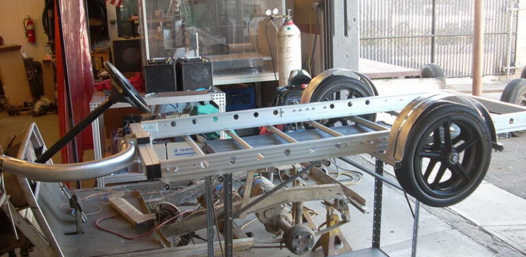 A wheeled metal frame under construction in a workshop